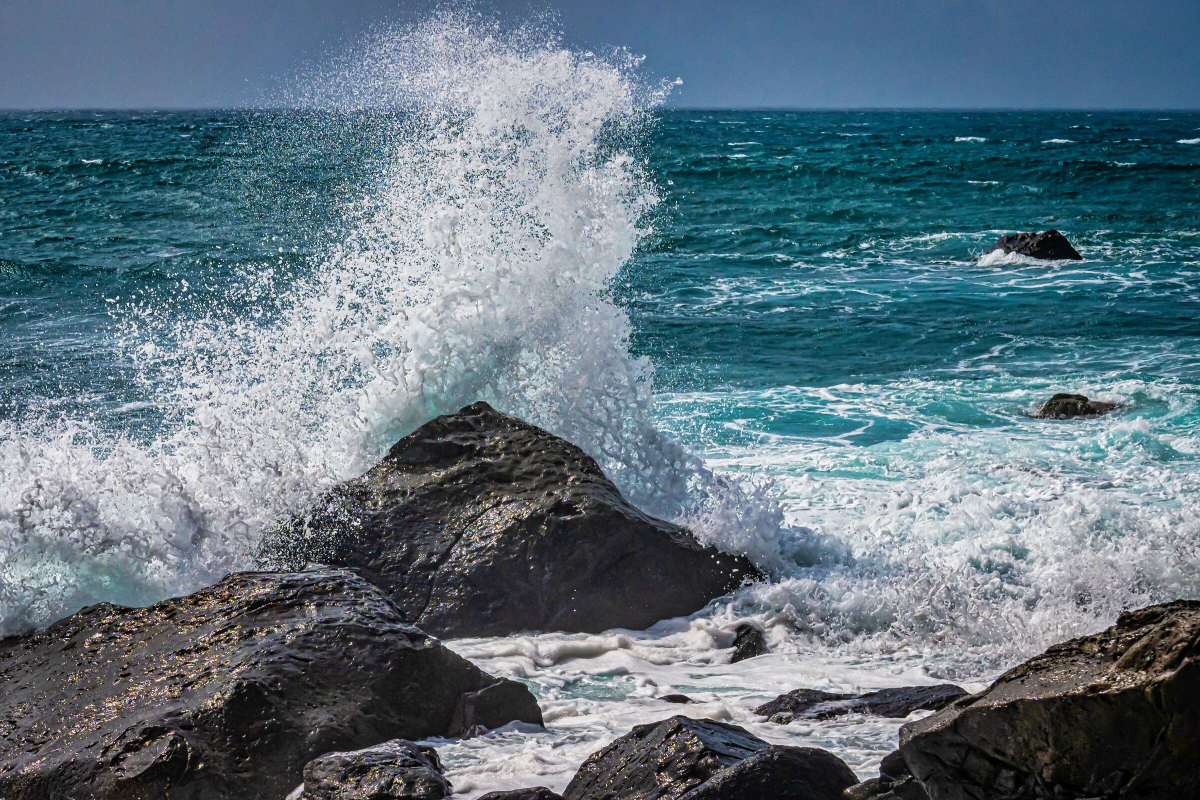 A stunning seascape featuring a powerful wave crashing against a large rock.